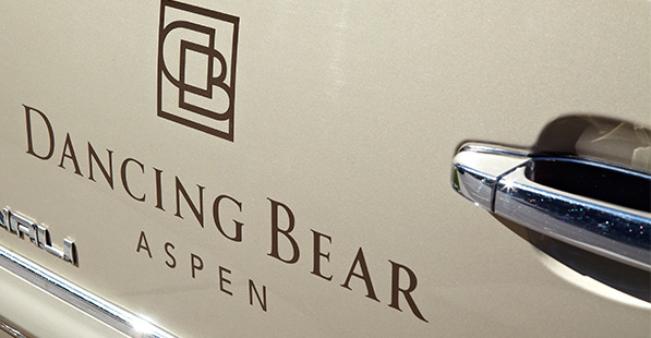 The Dancing Bear Aspen logo appears painted on a car door.